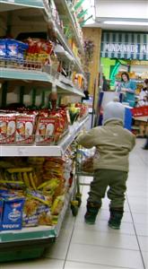 Child pushing a small shopping trolley through a supermarket