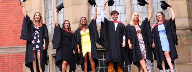 Students throwing their hats in the air outside Firth Court.