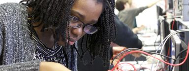 Female student using a circuit board in the Electronics lab