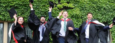Graduates jumping with hats in hands