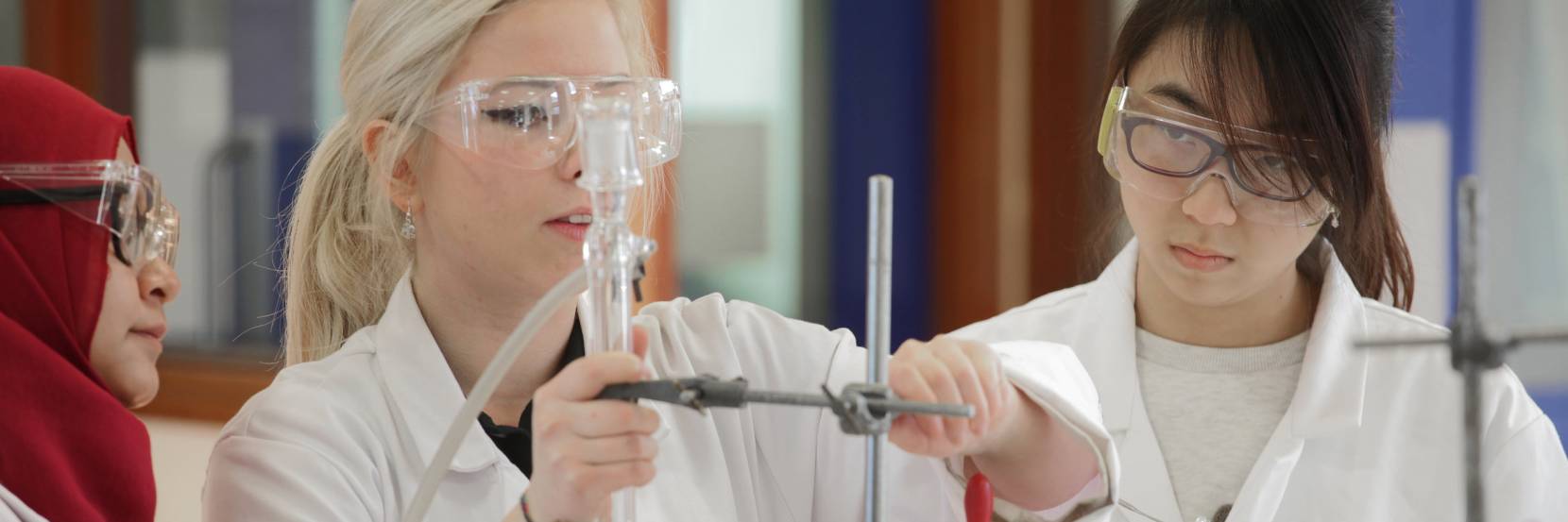 Three students setting up an experiment - image