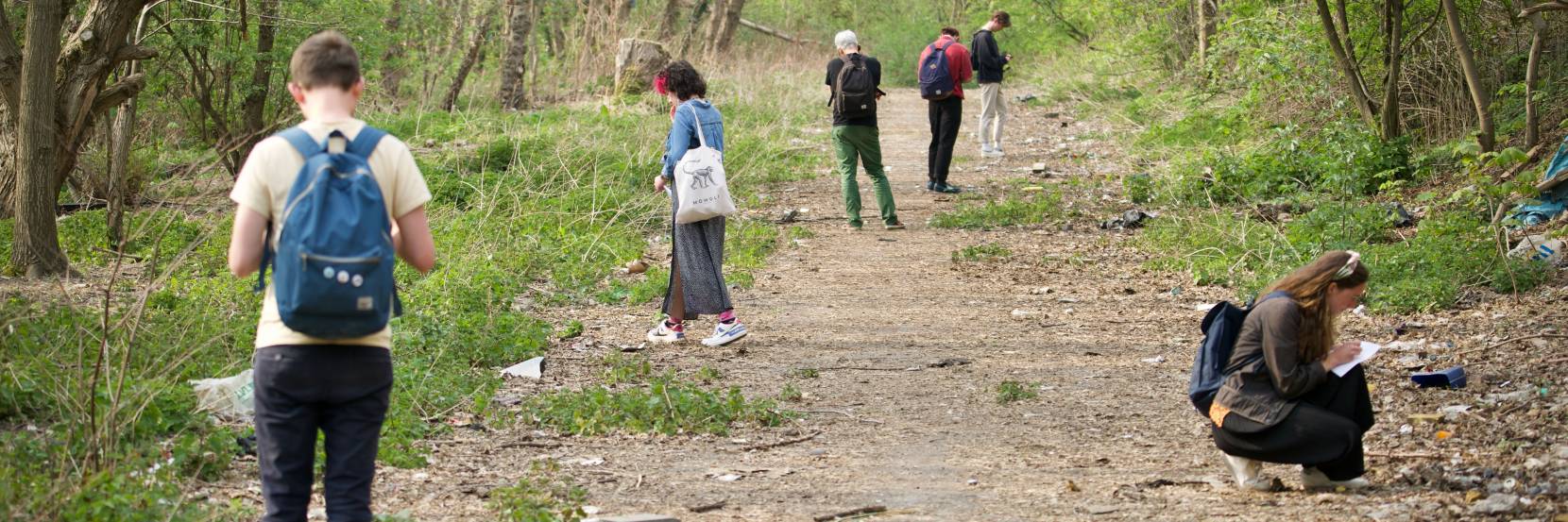 Students examine a woodland path as part of an urban exploration field class