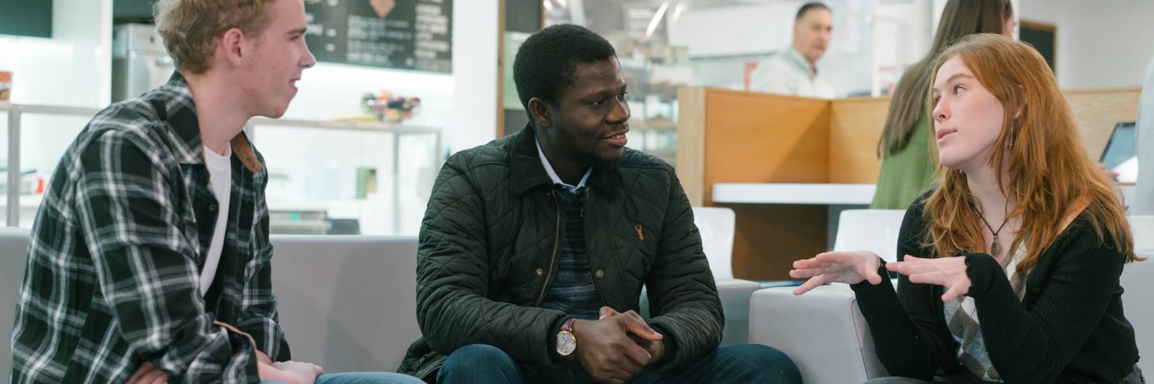 Two students talking to an academic in the cafe.