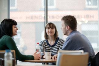 Image of three postgraduate history students sitting around table
