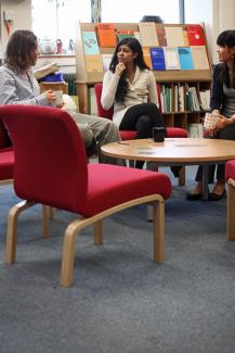 Group of postgraduate students from the Department of Maths and Statistics sitting around table on red chairs