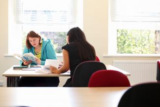 Postgraduate politics students reading at desk