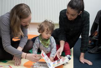 Postgraduate psychology students Evie Smith and Ciara Kelly reading with child