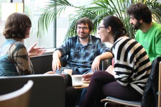 Postgraduate philosophy students sitting around coffee table