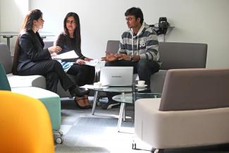 Three Computer Science postgraduates at table