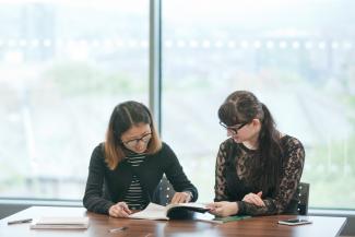 Postgraduate education students reading at desk