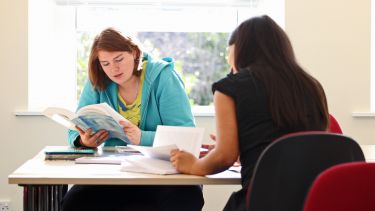 Postgraduate politics students reading at desk