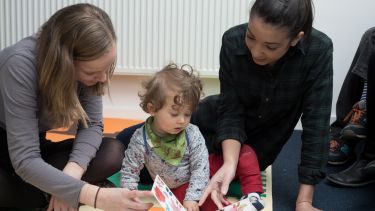 Postgraduate psychology students Evie Smith and Ciara Kelly reading with child