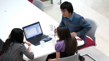 Group of Chemical and Biological Engineering postgraduates at a table with laptop