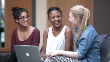 Three postgraduates with a laptop