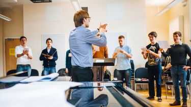 A group of postgraduates rehearsing