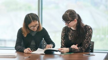 Postgraduate education students reading at desk