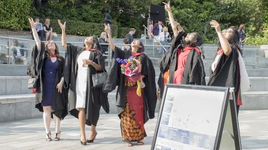 Graduates throw their hats on graduation day. 