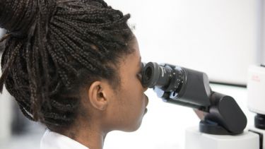 Student looking through microscope