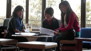 Students sitting around a table discussing work