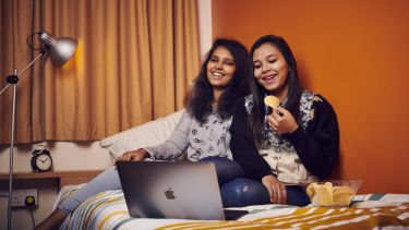 Students sat watching a laptop