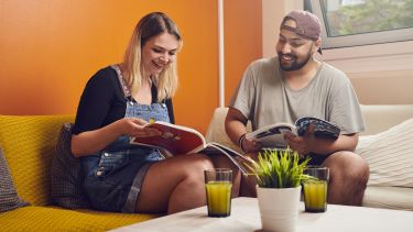 Two students reading magazines 