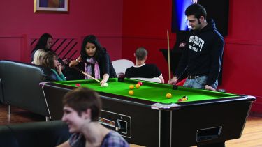 Students in accommodation playing pool.