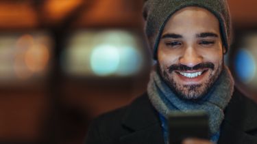 Man using a mobile phone outside at night