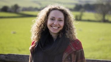 Image of PhD student, Teresa, in a green
