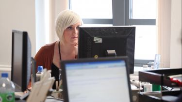 A student sat at a computer - image