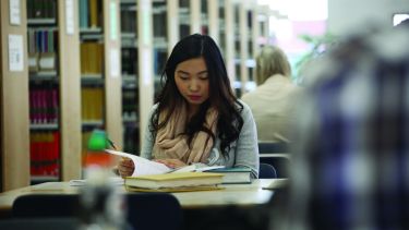 Student sat studying in library