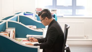 PhD students doing research at a desk in the PhD study space, Elmfield building