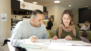 two mature students working in a cafe - image