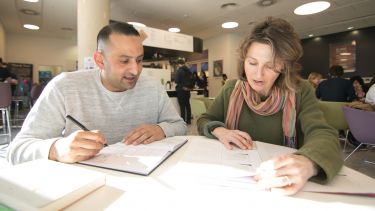 Two mature students working together in The Diamond cafe