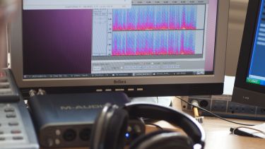 Student at a computer with recording equipment