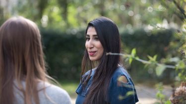 Postgraduate scholarship student talking to another student outside