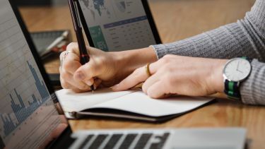 A woman working on research and writing notes.