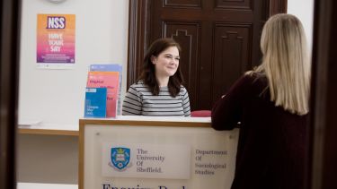 Student speaking to member of staff at the enquiry desk
