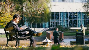 Student reading in Weston Park