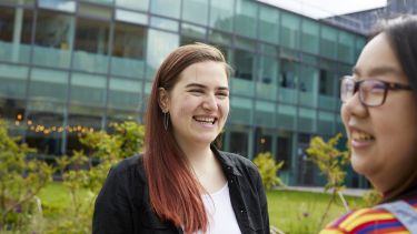 two students laughing outside the SU