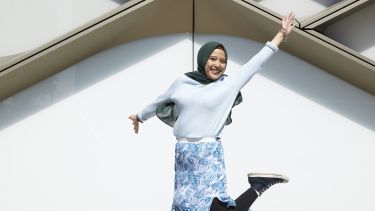 Student jumping outside the Diamond Building 