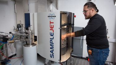 A researcher loads a sample into the 800 MHz spectrometer