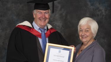 Joe Kavanagh collecting his Distinguished Alumni Award with Rosemary Boucher