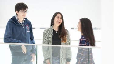 Three students laughing together - image