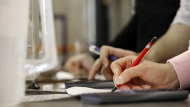 An image of student hands writing in a lab session
