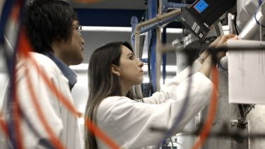 An image of two students working together in a lab