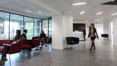 A photo of students sat in the lobby of the Management School.