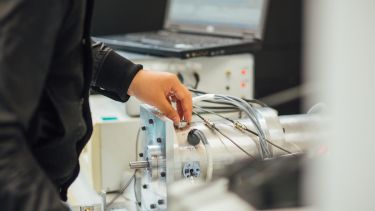 Postgraduate EEE student mending lab equipment