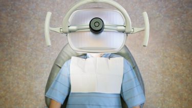 A dental patient in the dentist chair under the light. 