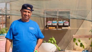 Syrian refugee with hydroponics-grown plants in the Zaatari refugee camp in Jordan