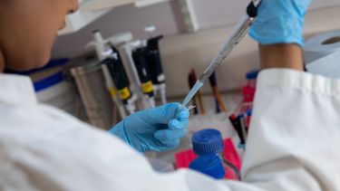 A medical student conducting research with a syringe. 